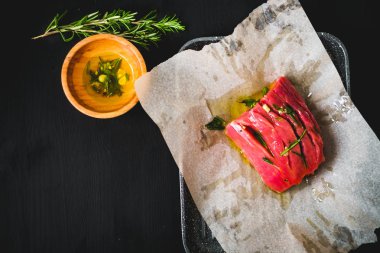 siyah zemin otlar ve sarımsak ile fırında pişirmeye ham sığır eti hazırlanmış