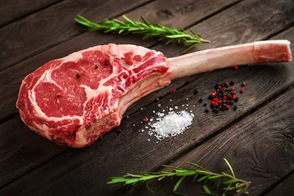 Ham Tomahawk biftek ızgara baharatlar ile ahşap arka plan üzerinde