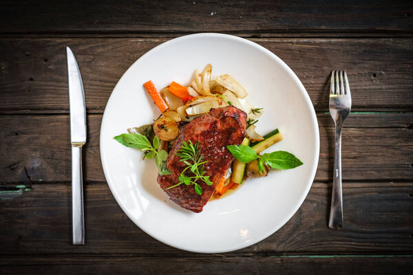 Grilled Striploin steak with vegetables on plate
