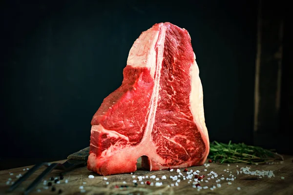 Nyers t csont steak fa sakktáblát, és a fekete háttér — Stock Fotó