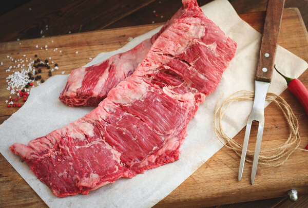 Raw machete steak a beef rustic style in wooden board