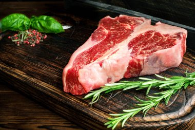 Pişmemiş porterhouse biftek otlar ile