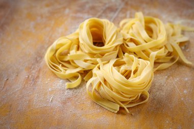 un ile ahşap bir masada taze tagliatelle makarna