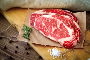 Hazırlanan bir masada ahşap bir Tahta üzerinde iki çiğ kaburga göz biftek 