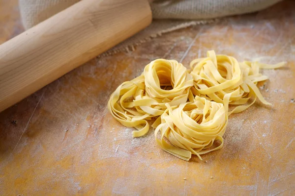 un ile ahşap bir masada taze tagliatelle makarna