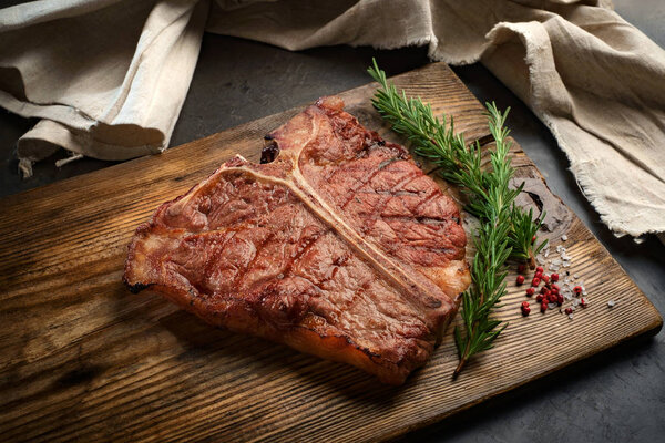 Porterhouse beef steak cooked on a grill on a wooden Board