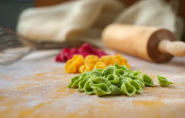 Домашняя паста свежего цвета на деревянном фоне, приготовление макарон — стоковое фото