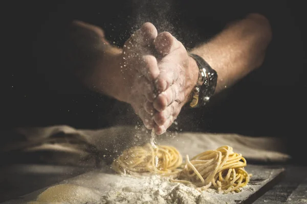 Chef men hands with flour splash over the table