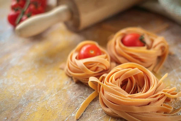 Raw tagliatelle nests uncooked on the wooden table — Stock Photo, Image