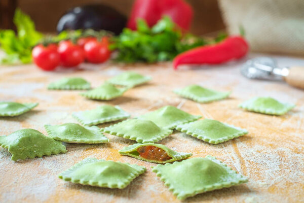 raw green homemade ravioli with spinach and vegetable on wooden 