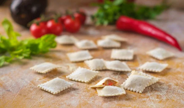 Ravioli crudi colorati in farina con verdure e pomodoro — Foto Stock