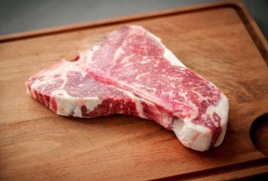 ahşap kasap tahta üzerinde kuru yaşlı t-kemik biftek