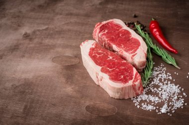 Ahşap tahta üzerinde iki taze ham striploin biftek