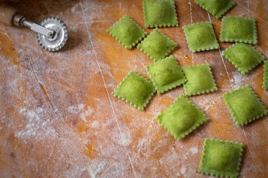 Ahşap arka planda un ile taze ev yapımı ravioli makarna