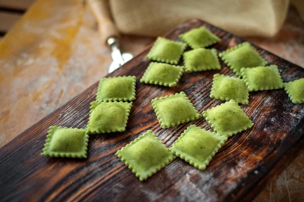 Colourful fresh ravioli with spinach on Board