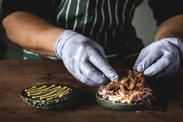 Chef en guantes prepara una hamburguesa brisket de carne — Foto de Stock
