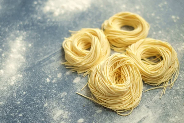 Сире домашнє гніздо спагетті з борошном на сірому фоні — стокове фото