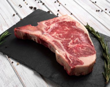 beyaz ahşap arka plan üzerinde bir taş Kurulu üzerinde ham kulüp biftek