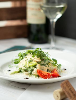 Kıtır ekmekli vejetaryen yeşil salatası, arkada bir bardak şarap.