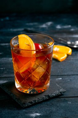 Koyu ahşap arka planda buzlu ve narenciyeli viski ve kola.