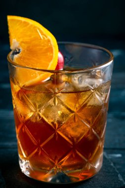 Koyu ahşap zemin üzerine buz ve narenciye kokteyle sahip Küba Libre