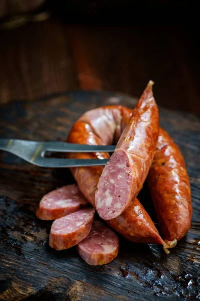 Bavarian smoked sausages from pork cut on a wooden Board. Rustic style