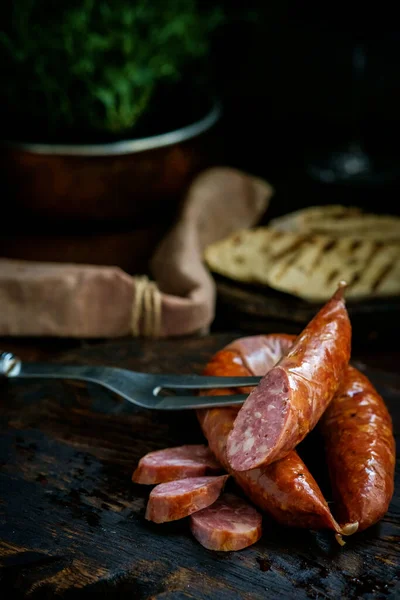 Bavarian smoked sausages from pork cut on a wooden Board. Rustic style