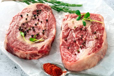 Beyaz Kraft kağıdında baharatlı iki çiğ mermer biftek. Organik taze et kavramı