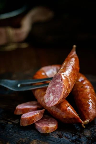 Bavarian smoked sausages from pork cut on a wooden Board. Rustic style