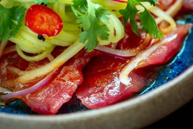 Salamura edilmiş, yeşil maydanozlu, soğanlı ton balığı fileto. Taze balık.