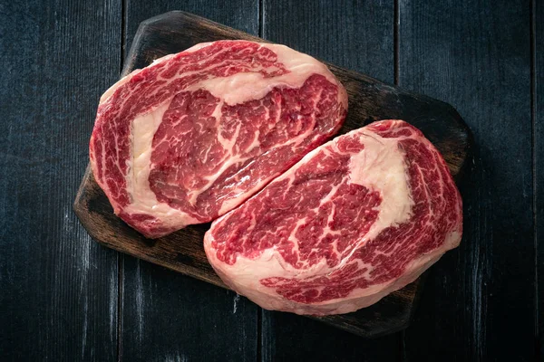 Perfektes Roh Rib Eye Rindersteak Auf Schwarzem Holzhintergrund Draufsicht — Stockfoto