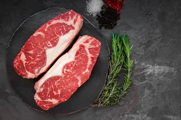 Roh Gestreiftes Rindersteak Mit Rosmarin Salz Und Pfeffer Auf Rundem — Stockfoto