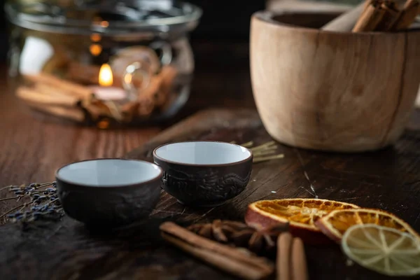 Ceramic cups with herbs for Chinese tea ceremony on dark background.