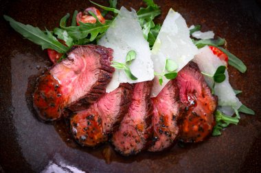 İtalyan salatasıyla bir tabakta dilimlenmiş sığır filetosu pişirilmiş fileto. Barbekü kurutulmuş wagyu sığır filetosu bifteği