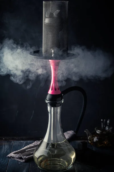 Smoking hookah on a black wooden background