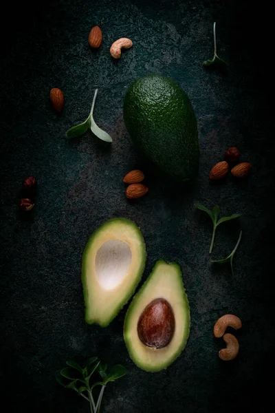 Rijp Avocado Tweeën Gesneden Met Noten Groene Bladeren Een Donkere — Stockfoto