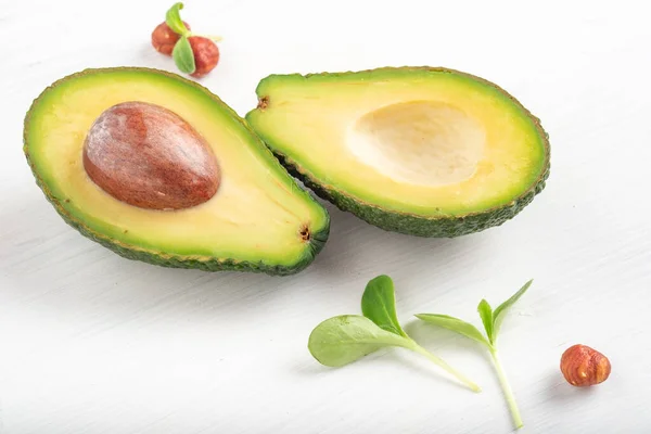 Rijp Avocado Gesneden Twee Delen Een Witte Houten Achtergrond Met — Stockfoto