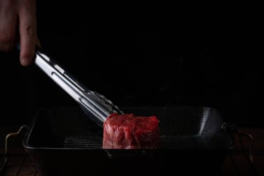 Tavadaki fileto mignon bifteği maşayla çevirilir, ızgarada pişirme işlemi...