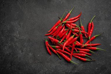 Siyah bir taşın üstünde kırmızı biber yığını.