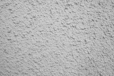 Gri duvarın pürüzlü dokusu, evin dış cephesi alçıdan oluşmuş.