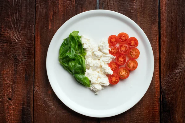 Ingredients for Caprese salad in the form of a heart. Italian flag from traditional food products
