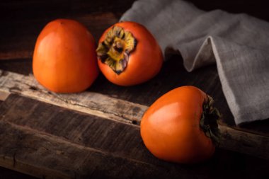 Olgun hurma meyvesi eski ahşap masada, yakın plan.