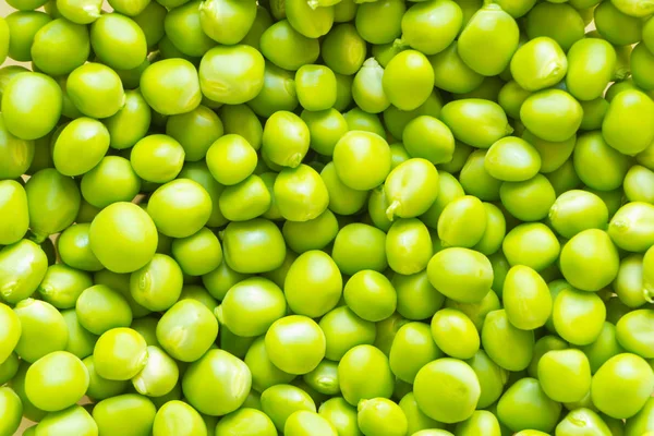 Light-green fresh peas peeled from pods. Background.