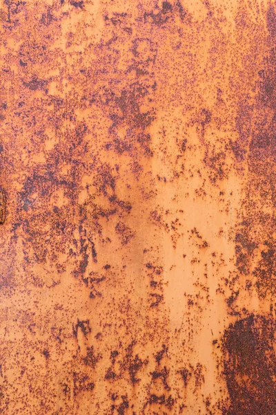 Weathered metal with orange rust. Detail rusted metal texture for background. Vertical photography.