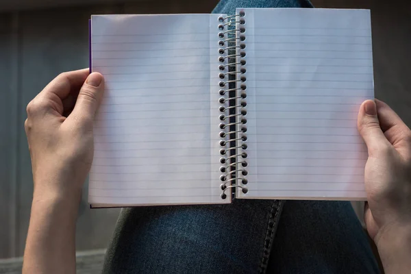 妇女的手拿着打开内衬的笔记本与内衬页在圈 — 图库照片