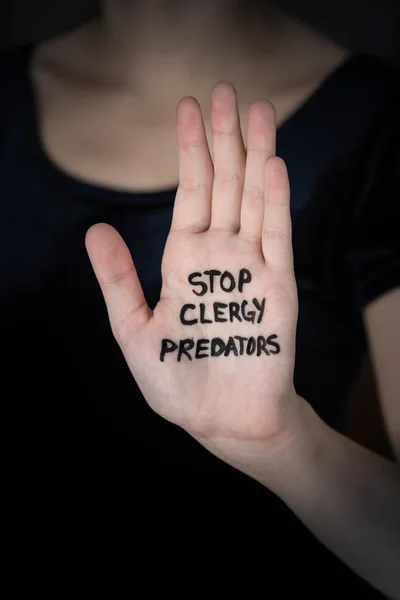 Hand held up in stop gesture with words Stop Clergy Predators written on palm — Stock Photo, Image