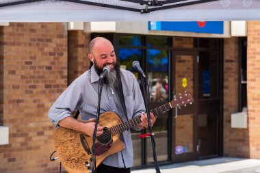 Penticton, British Columbia/Kanada - 15 Haziran 2019: Güney Okanagan'ın en büyük açık hava pazarı olan Penticton Community Market'te bir müzisyen sahne alıyor