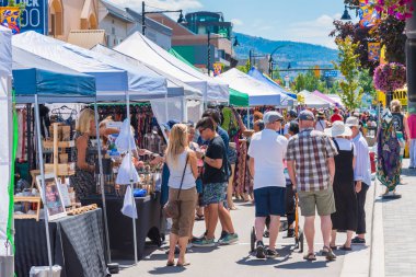 Penticton, British Columbia/Kanada - 15 Haziran 2019: Popüler bir haftalık etkinlik olan Penticton Community Market için alışveriş yapanlar ve satıcılar Ana Cadde'yi dolduruyor.