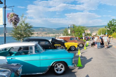 Penticton, British Columbia/Kanada - 21 Haziran 2019: Kuzey Amerika'nın en büyük otomobil gösterilerinden biri olan Peach City Beach Cruise'un sergilenen araçlarına insanlar bakıyor.