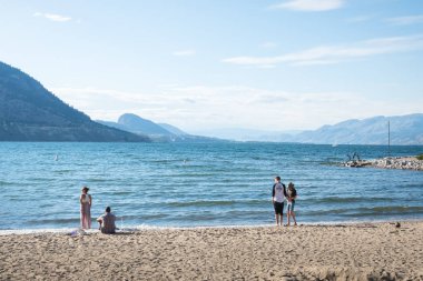 Penticton, British Columbia/Kanada - 22 Haziran 2019: Turistler ve yerliler için popüler bir yer olan Okanagan Plajı'nda güzel bir akşamın tadını çıkaran insanlar
